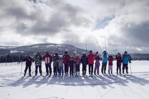 a group of skiers posing for a picture in the snow at Dvorská Bouda in Strážné