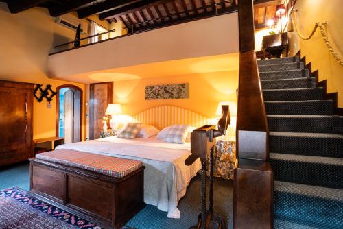 a bedroom with a bed and a staircase with a stair case at Villa Abbazia Relais & Chateaux in Follina