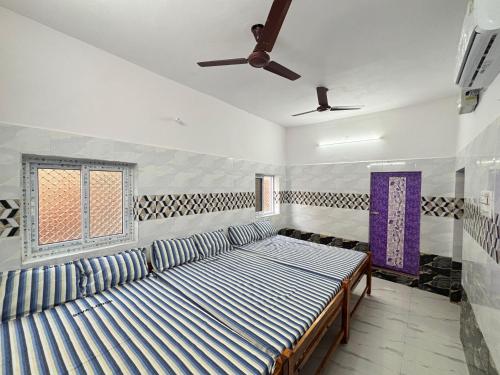 a room with a couch and a window at Siva Lodge in Rāmeswaram