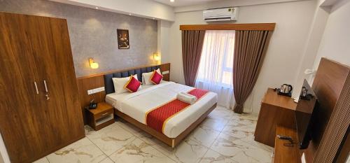 a hotel room with a bed and a window at Royal Palace in Chāvasseri