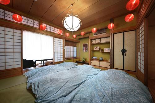 a bedroom with a large bed in a room with lights at リトリート禅の宿 in Owariasahi
