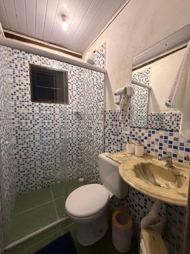 a bathroom with a toilet and a sink at Chalé com vista na vila centro histórico in Ilhabela
