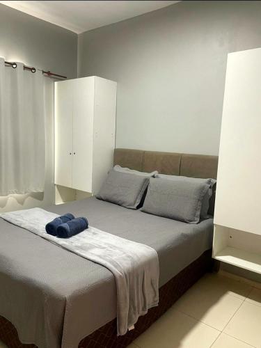 a bedroom with a bed with a blue hat on it at DUNAS RESIDENCE CASA 12 in Santo Amaro
