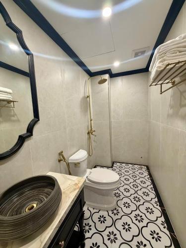 a small bathroom with a toilet and a shower at Indocharm Villa Cat Ba in Cat Ba