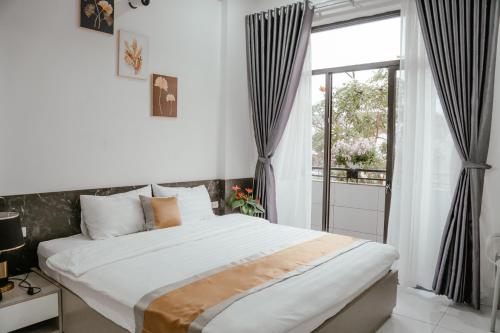 a bedroom with a large bed and a window at DeHa Homestay in Hue