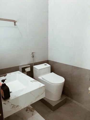 a bathroom with a white toilet and a sink at DeHa Homestay in Hue