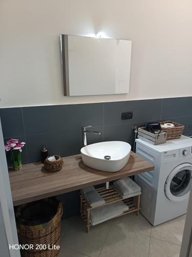a bathroom with a sink and a washing machine at Mama Etna in Belpasso