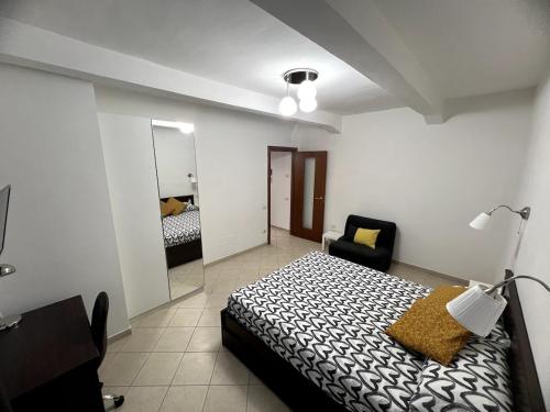 a bedroom with a bed and a chair and a mirror at Casa Paoli in Salerno