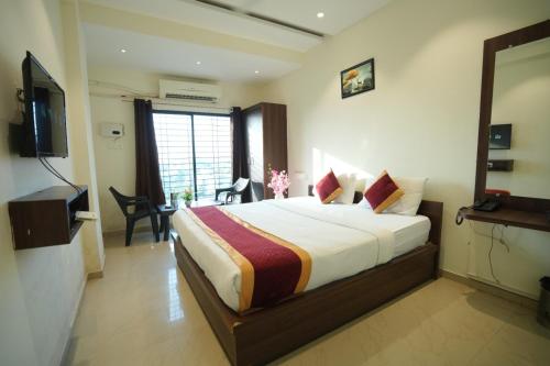 a hotel room with a bed and a television at Hotel Seva in Nagpur