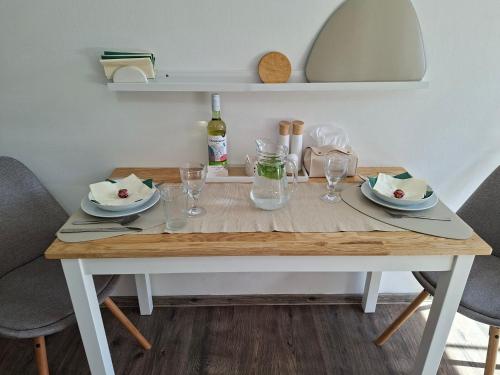 a wooden table with plates and glasses on it at Apartmán 29 LANOVKA in Jáchymov