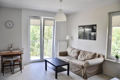 ein Wohnzimmer mit einem Sofa und einem Tisch in der Unterkunft Apartamenty Tespis - Andersa in Kattowitz