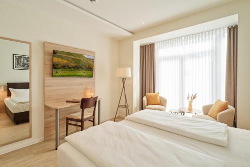 a hotel room with a bed and a desk at Hotel und Weingut Karlsmühle in Mertesdorf