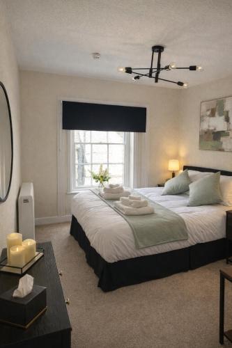 a large bedroom with two beds and a window at Charming 3 Bedroom High St Apartment in Much Wenlock