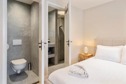 a bedroom with a white bed and a toilet at Boetiek ManjaFiek in Zandvoort