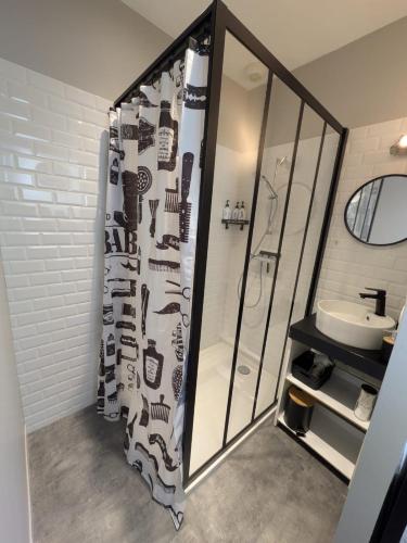 a bathroom with a shower curtain and a sink at Chambre la Belle Étape in Martinet