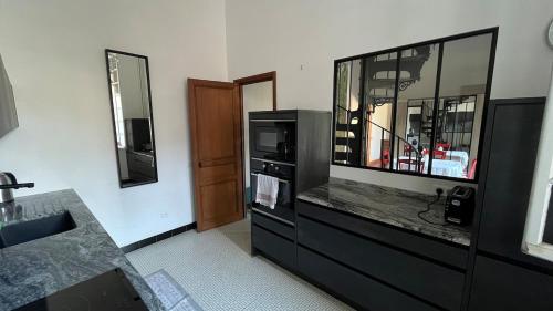 a bathroom with a sink and a tv and a counter at Le Chanoine - Centre Ville - Sens in Sens