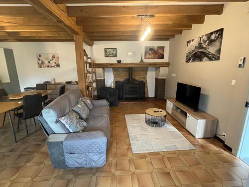 a living room with a couch and a fireplace at Un air de campagne climatisé - Cure thermale ou vacances in Saint-Loubouer