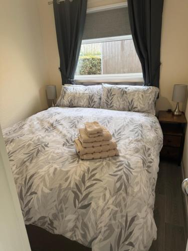 a bed with two towels sitting on top of it at 2 Broadside Chalet Park in Stalham