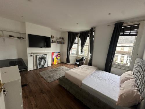 a bedroom with a large bed and a fireplace at Massive cozy room with shared bathroom in Thornton Heath