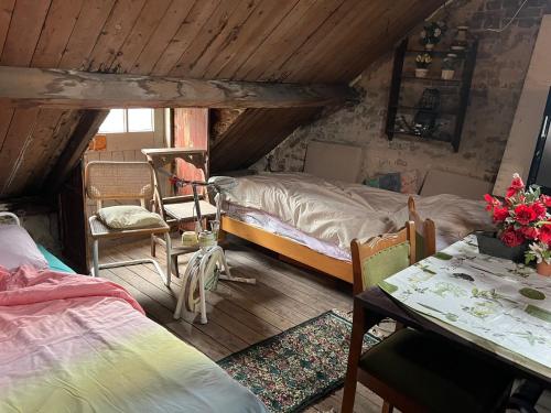 a bedroom with two beds and a table and chairs at Het werkhuis, terug in de tijd in Uden