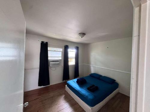 a small room with a blue bed and a window at La Cienega Near The Grove & Public Transit in Los Angeles
