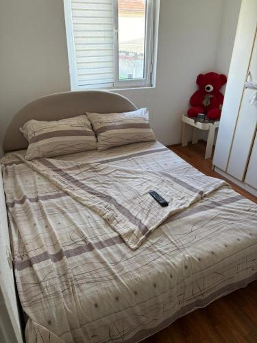 a bed with a remote control sitting on top of it at Sweet home Jagodina in Jagodina