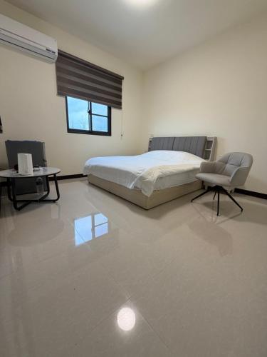 a bedroom with a bed and a table and a chair at Siwei B&B in Hou-k'u-t'an