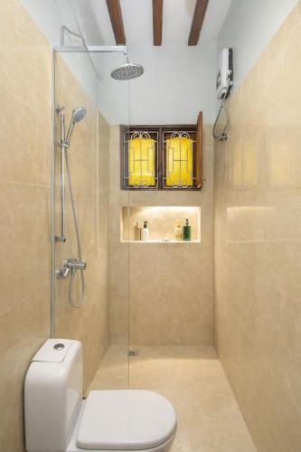 a bathroom with a toilet and a glass shower at Majani Breeze Zanzibar in Nungwi