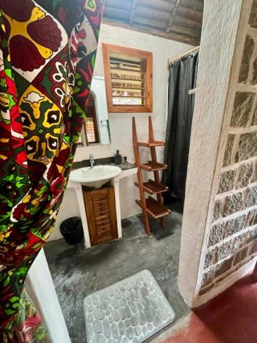 a bathroom with a sink and a mirror and a shower at Tamarin Lodge in Ampangorinana