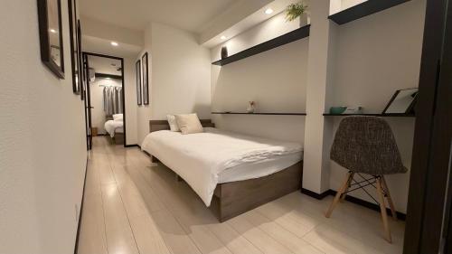 a bedroom with a bed and a chair in it at 福源阁-日式别墅-整栋独享-新深江站步行5分-90平方6人入住-难波心斋桥直达8分-3室两卫-洗烘一体机 in Osaka