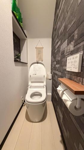 a bathroom with a toilet with a brick wall at 福源阁-日式别墅-整栋独享-新深江站步行5分-90平方6人入住-难波心斋桥直达8分-3室两卫-洗烘一体机 in Osaka