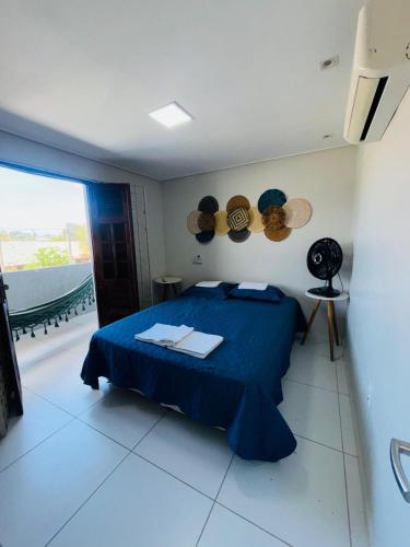 a bedroom with a blue bed and a balcony at Labonita House - Pilar in Itamaracá