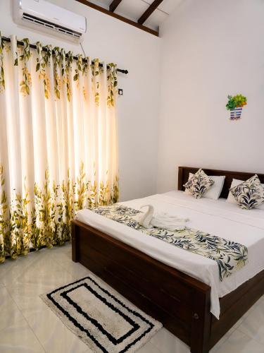 a bedroom with a large bed with curtains at Udara Guest - Yala Safari in Yala