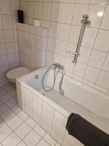 a white bathroom with a tub and a toilet at Herzstück in Grafenrheinfeld