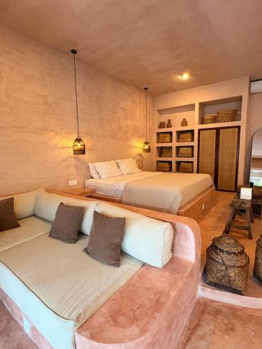 a bedroom with two beds and a couch at Le Bohémien Suites Cabana in Dalung
