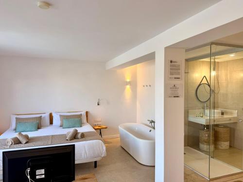 a bedroom with a bed and a tub and a sink at Ocean Suite by SHC with heated pool only for adults in Telde
