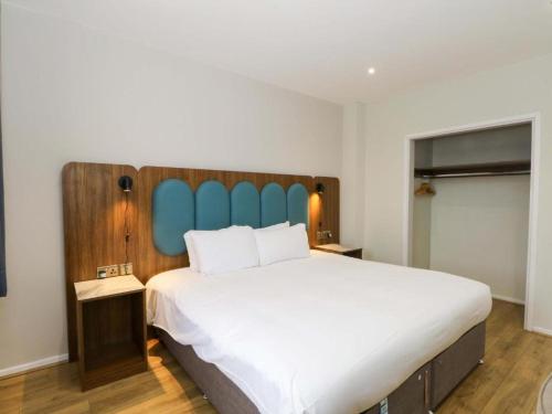 a bedroom with a large bed with a blue headboard at Park Hall Cottages ,Chorley, Preston,Lancashire in Chorley