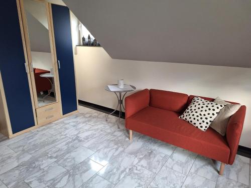 ein Wohnzimmer mit einem roten Sofa und einem Tisch in der Unterkunft Eselblick in Steinwenden