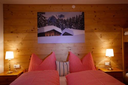 a bedroom with two beds with red pillows at Ferienhaus Oberboden in Schröcken