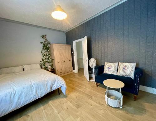 a bedroom with a bed and a chair and a table at Rose Cozy House in Stockton-on-Tees