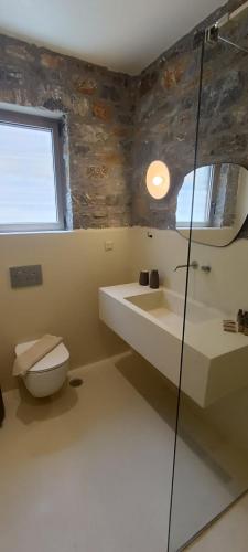 a bathroom with a toilet and a sink at Piperi Suites in Kithnos