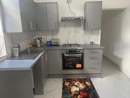 a kitchen with a stove and a sink at Princess shahzadi in Manchester