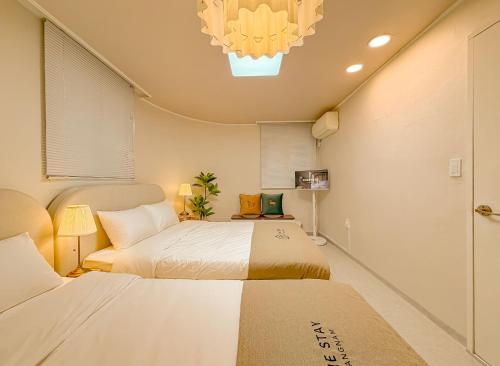 a bedroom with two beds and a chandelier at The Stay Gangnam COEX Hanti Station 5 minutes! 3Queen Bed in Seoul