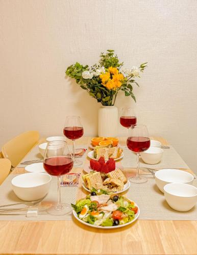 a table with glasses of wine and a plate of food at The Stay Gangnam COEX Hanti Station 5 minutes! 3Queen Bed in Seoul