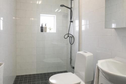 a white bathroom with a toilet and a sink at Grynnan in Skå