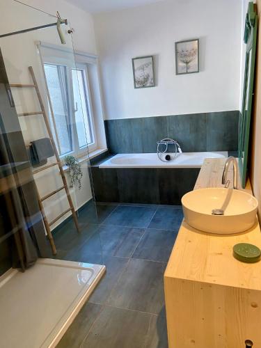 a bathroom with a sink and a bath tub at A l'ombre du cèdre in Grez-Doiceau