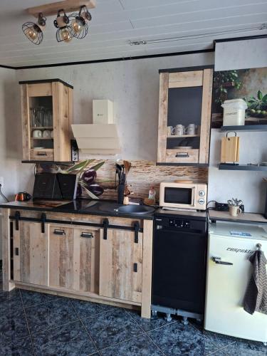 a kitchen with wooden cabinets and a black and white appliance at ruhiger als im Hotel keine andere Gäste 3 Betten 2 Schlafzimmer in Merkendorf