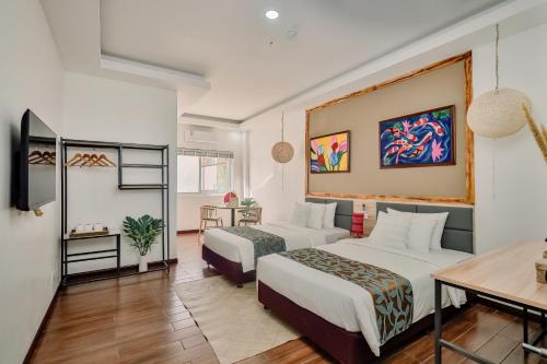 a hotel room with two beds and a table at Kabesera Bed and Coffee in Binangonan