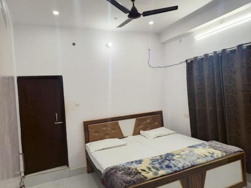 a bedroom with a bed and a ceiling fan at Sai holidays in Ayodhya