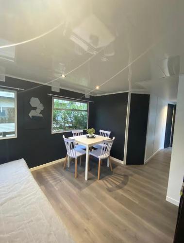 a dining room with a white table and chairs at Mobil-home dans un camping calme et familial chez César in Cambo-les-Bains